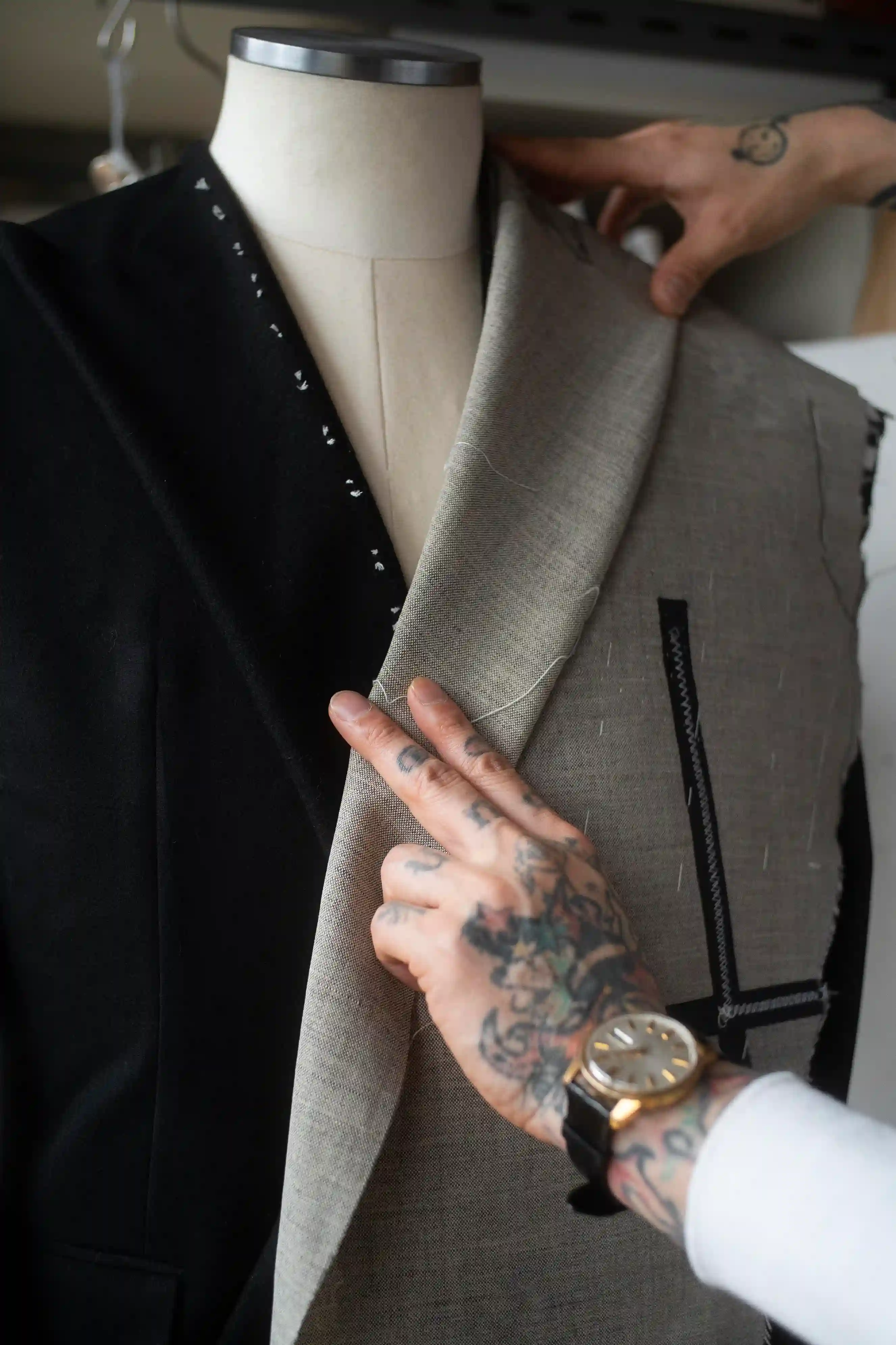 Hands fitting fabric onto a tailored jacket on a mannequin